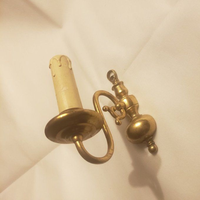 Applique murale en laiton doré et patiné, au design inspiré des anciens bougeoirs. 